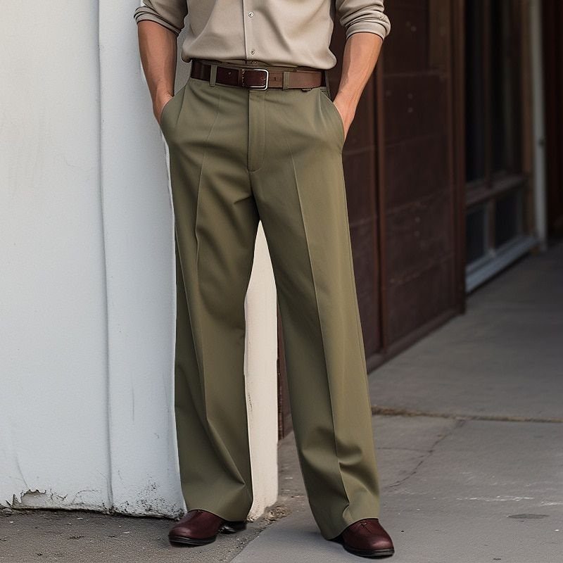Man wearing olive green tailored trousers with a beige shirt and brown leather belt.