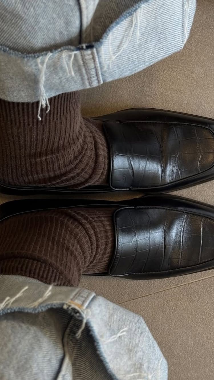 Brown ribbed knit socks worn with black leather loafers and light blue denim jeans.