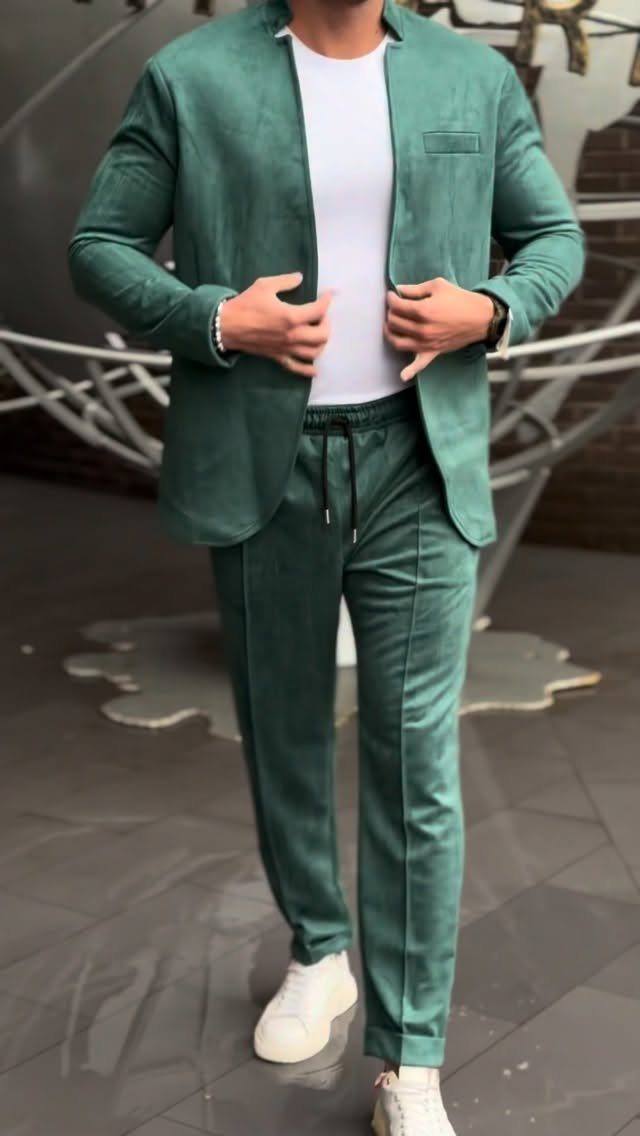 Man wearing a teal green casual suit with a white t-shirt and white sneakers.