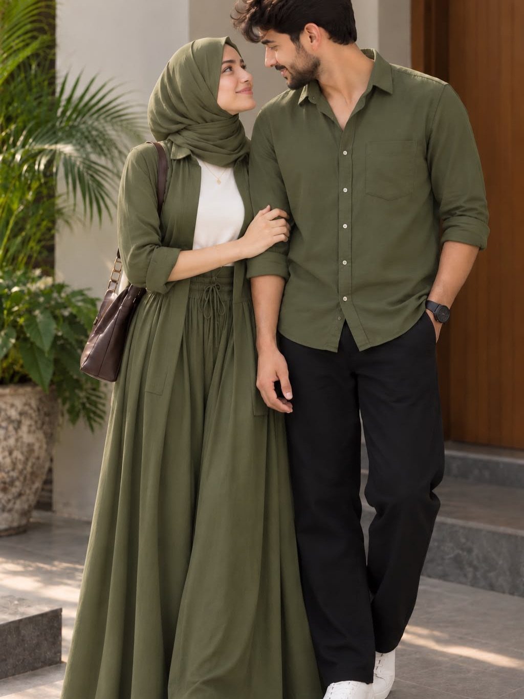 A man and a woman wearing coordinated olive green clothing walking together outdoors.