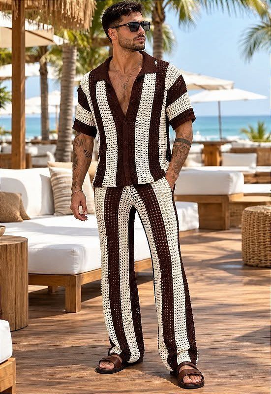 Man in a striped brown and white summer beach outfit standing on a sunny wooden deck.